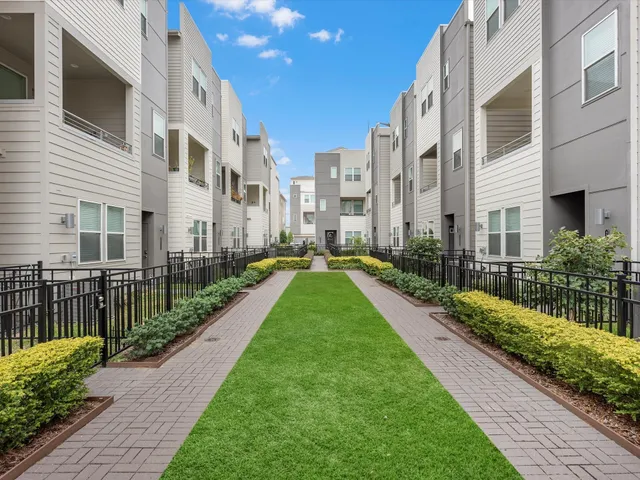 a view of a street with a yard and plants