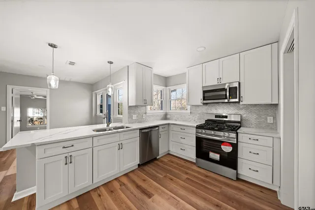 a kitchen with stainless steel appliances granite countertop a sink and cabinets
