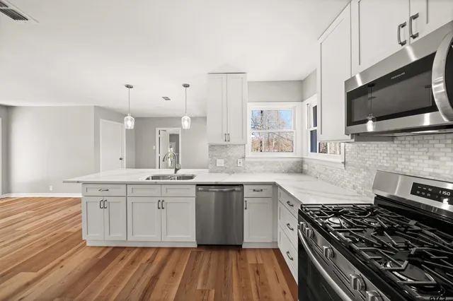 a large kitchen with stainless steel appliances granite countertop a stove and a sink