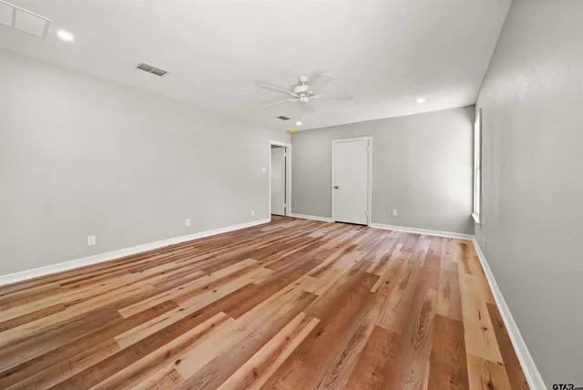 a view of empty room with wooden floor