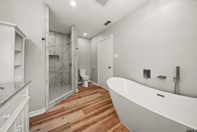 a spacious bathroom with a bathtub and shower