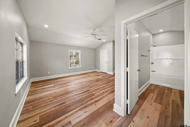 a view of a hallway with wooden floor and staircase