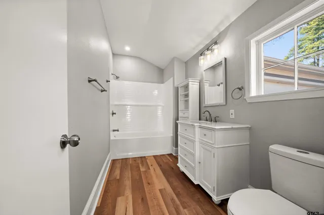 a bathroom with a sink toilet granite tub and shower