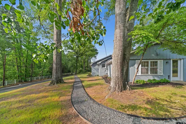 a view of a house with swimming pool next to a yard