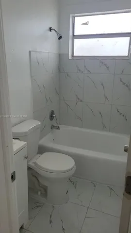 a white toilet sitting next to a bath tub