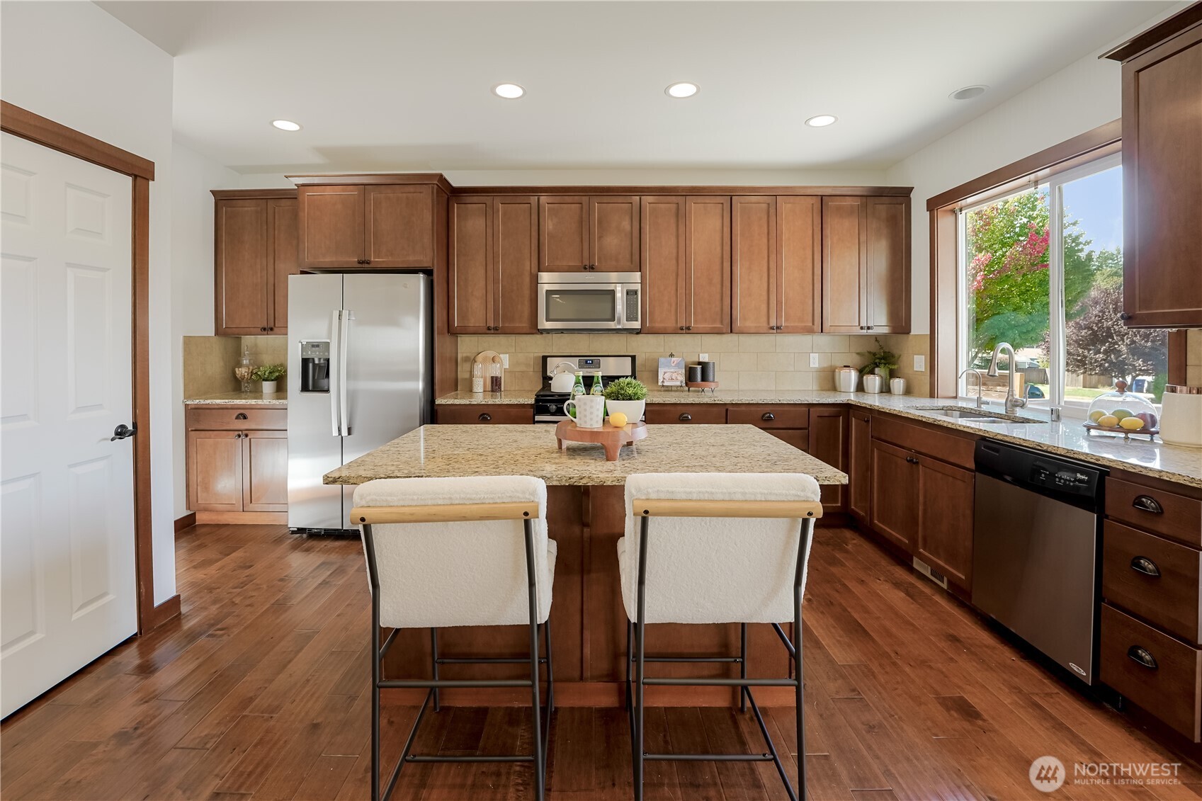 607 217th Street Southwest Bothell, WA 98021 - Photo 7 of 36 a kitchen with a table chairs refrigerator microwave and cabinets