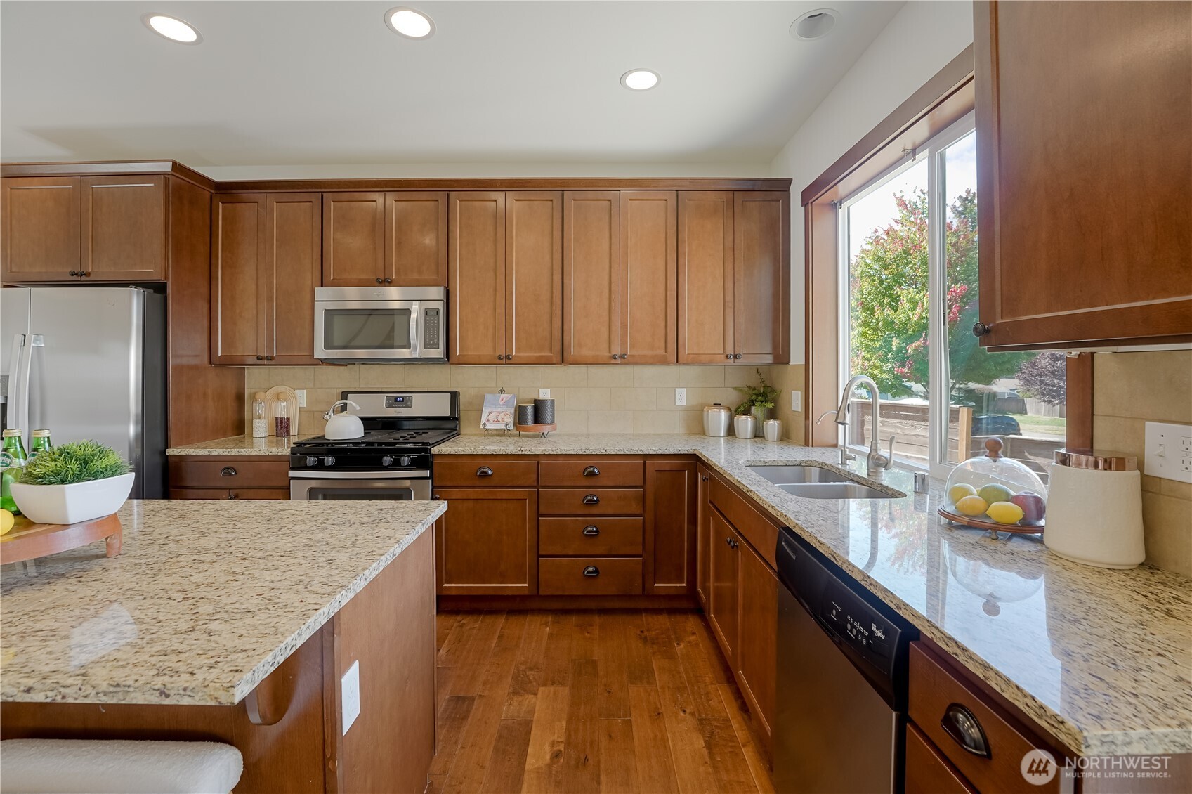 607 217th Street Southwest Bothell, WA 98021 - Photo 8 of 36 a kitchen with stainless steel appliances granite countertop a stove a sink dishwasher and a refrigerator with wooden floor
