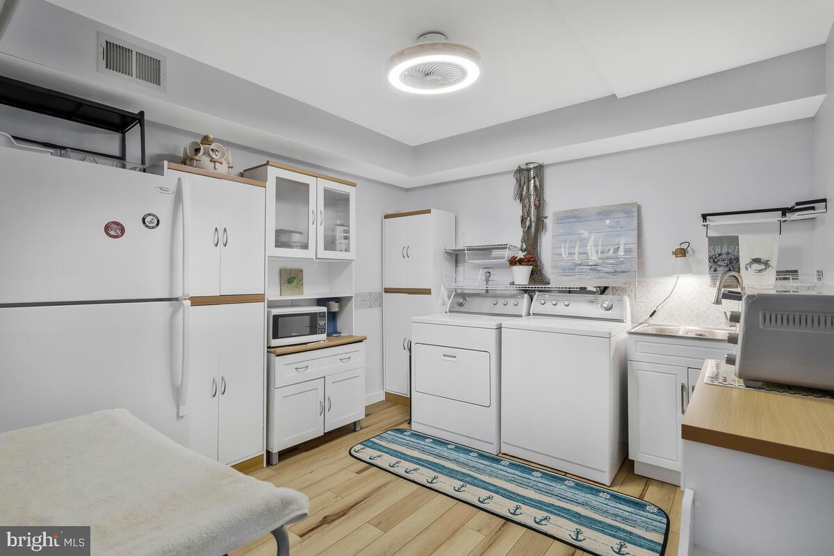 263 Frontier Trail Lusby, MD 20657 - Photo 73 of 94 a kitchen with white cabinets and white appliances