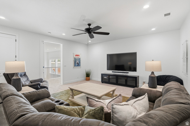 2278 Tawny Ridge Circle St. George, UT 84790 - Photo 39 of 61 Spacious media room featuring recessed lighting, a ceiling fan, light-colored carpeting, a wall-mounted television, and a media console with glass-front cabinets.