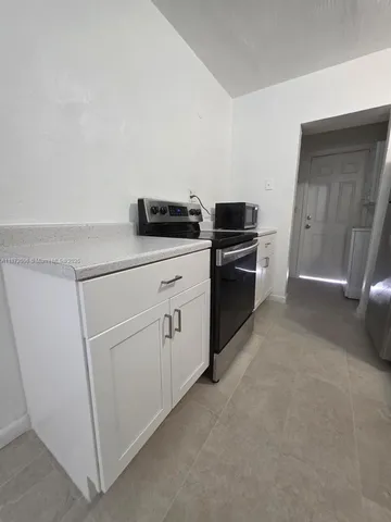 a kitchen with white cabinets and white appliances