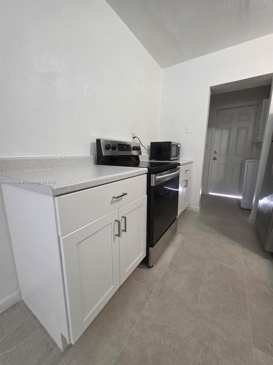 511 Northwest 4th Avenue, Unit 2 Hallandale Beach, FL 33009 - Photo 11 of 28 a kitchen with white cabinets and white appliances