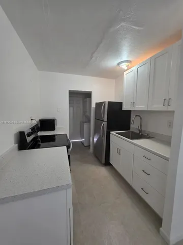 a kitchen with stainless steel appliances a refrigerator sink and cabinets