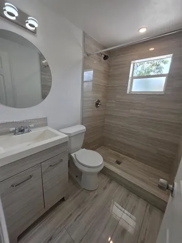 a bathroom with a toilet a sink and mirror