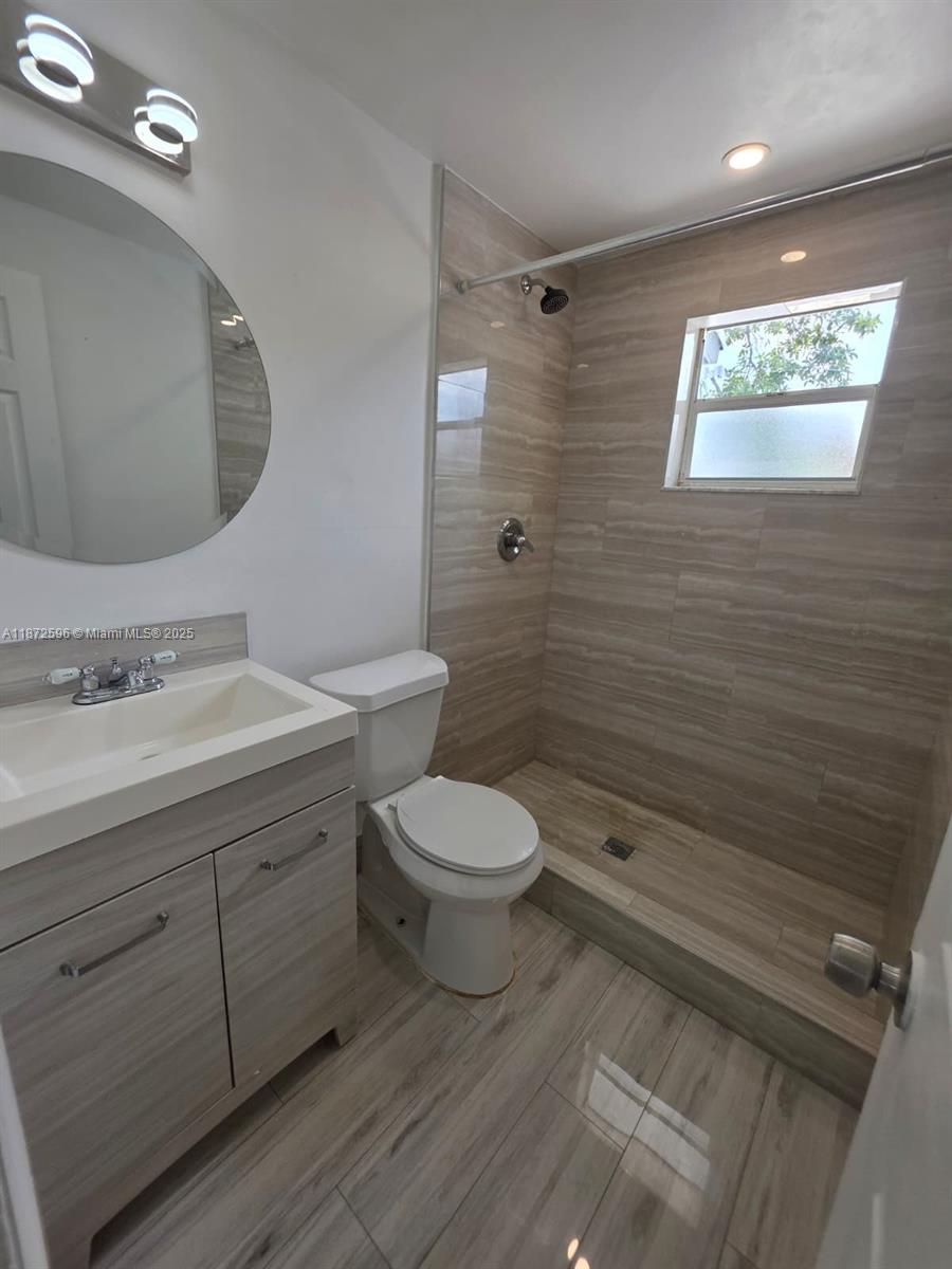 511 Northwest 4th Avenue, Unit 2 Hallandale Beach, FL 33009 - Photo 21 of 28 a bathroom with a toilet a sink and mirror