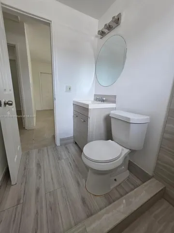 a bathroom with a toilet a sink and mirror