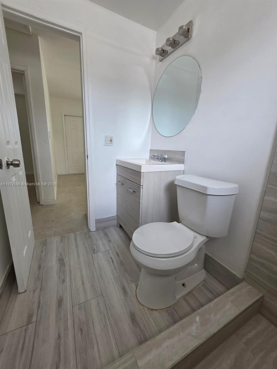 511 Northwest 4th Avenue, Unit 2 Hallandale Beach, FL 33009 - Photo 22 of 28 a bathroom with a toilet a sink and mirror
