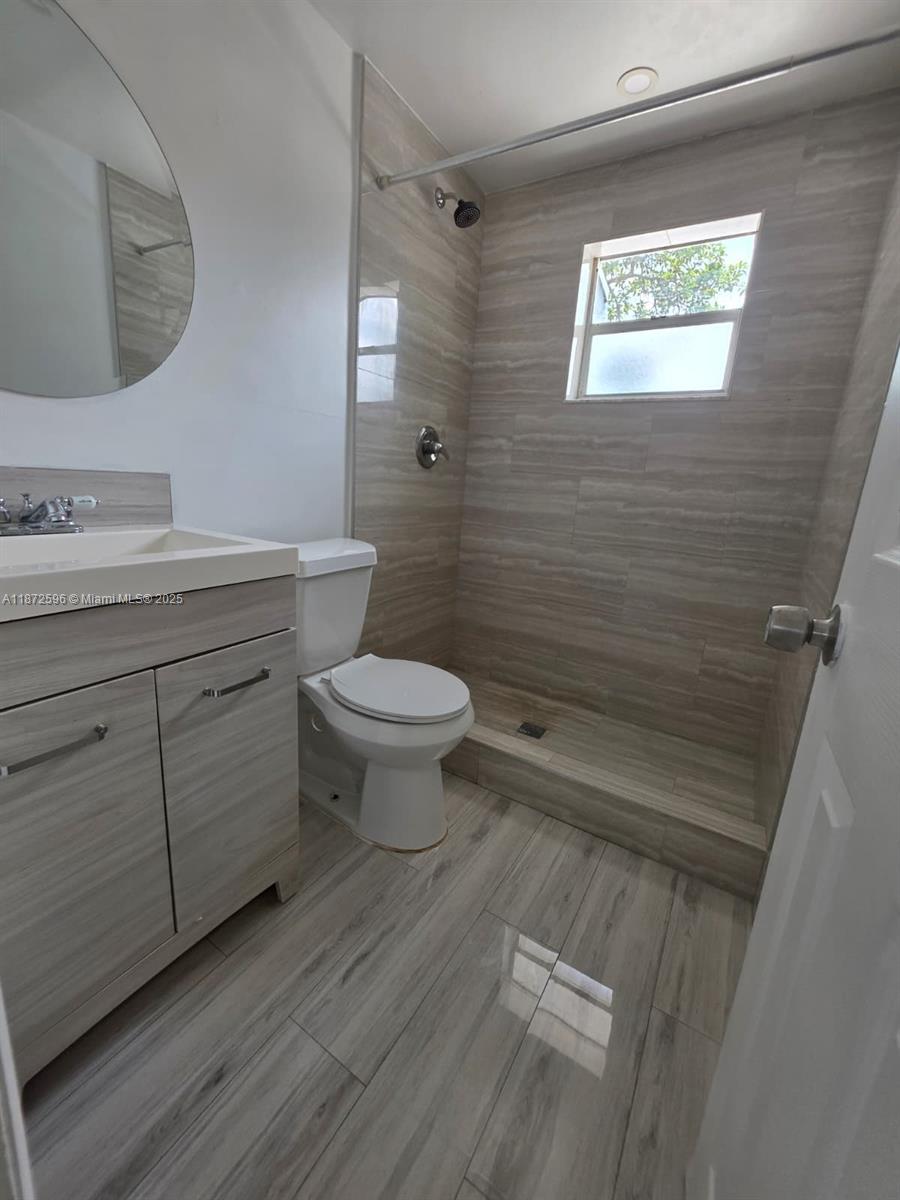 511 Northwest 4th Avenue, Unit 2 Hallandale Beach, FL 33009 - Photo 23 of 28 a bathroom with a toilet sink and mirror