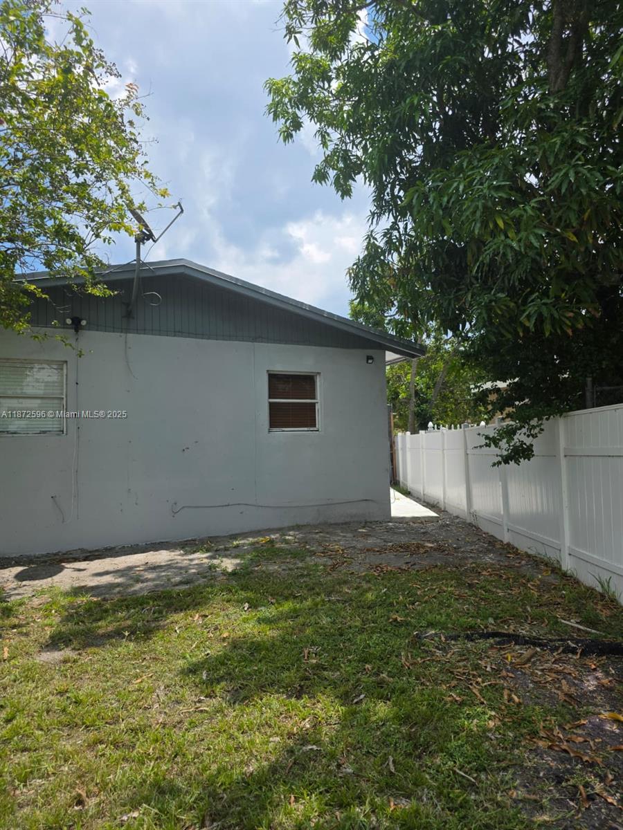 511 Northwest 4th Avenue, Unit 2 Hallandale Beach, FL 33009 - Photo 27 of 28 a backyard of a house with lots of plants and tree