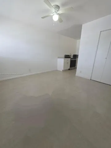 a view of a room with a ceiling fan and window