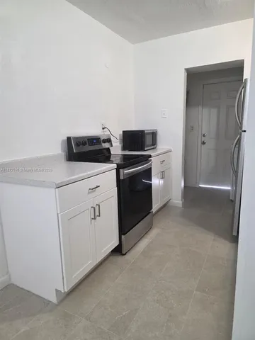 a kitchen with white cabinets and white appliances