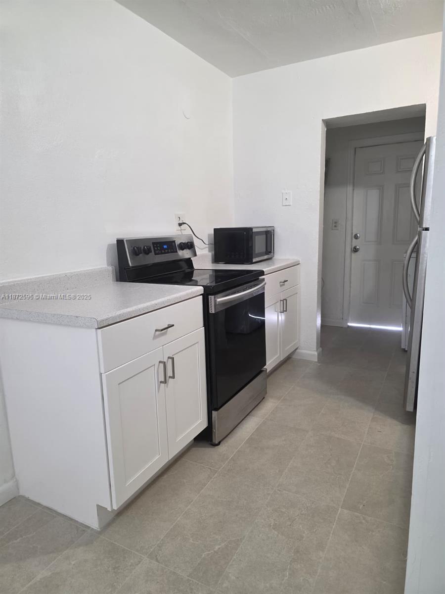 511 Northwest 4th Avenue, Unit 2 Hallandale Beach, FL 33009 - Photo 9 of 28 a kitchen with white cabinets and white appliances