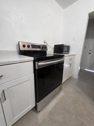 a kitchen with a stove and white cabinets