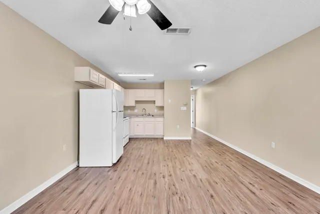 a view of a kitchen with a sink wooden floor and a window