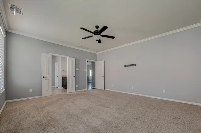 an empty room with closet and a ceiling fan