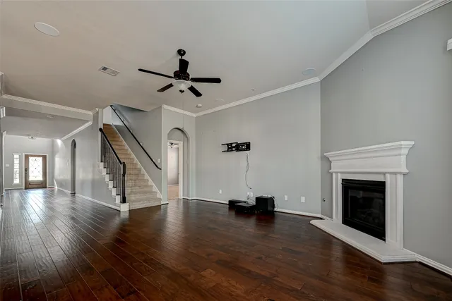 a view of an empty room with wooden floor fireplace and a window