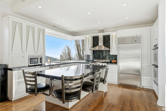 1878 East Ridge Point Drive Bountiful, UT 84010 - Photo 11 of 92 Kitchen featuring a kitchen bar, built in appliances, recessed lighting, light wood-style floors, and white cabinetry