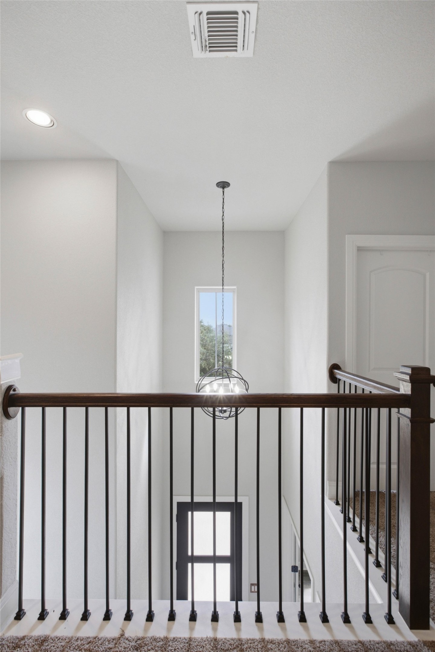 1113 Modoc Way Kyle, TX 78640 - Photo 21 of 34 A striking modern chandelier illuminates this grand multi-level entryway, framed by elegant railings.