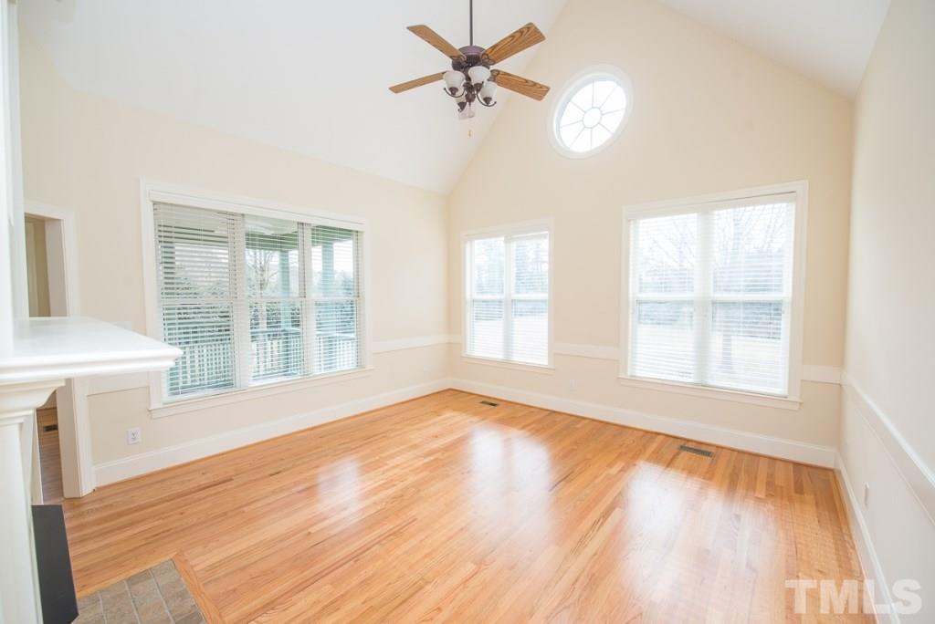 4528 Deer Stream Lane Raleigh, NC 27603 - Photo 7 of 25 Family room with cathedral ceiling, fan, chair rail molding and gas fireplace.