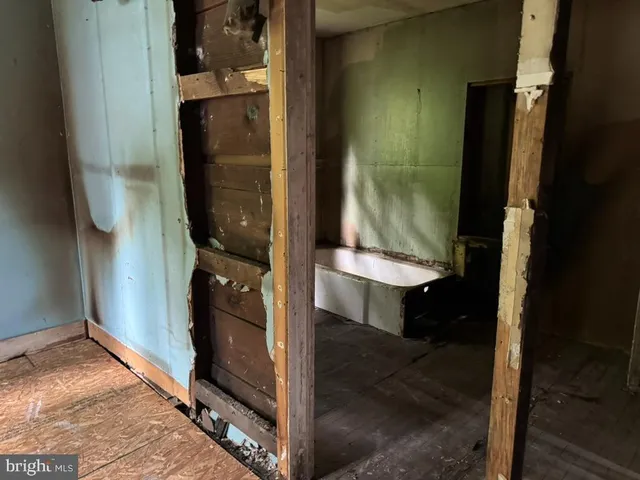 a view of an empty room with a fireplace and a window