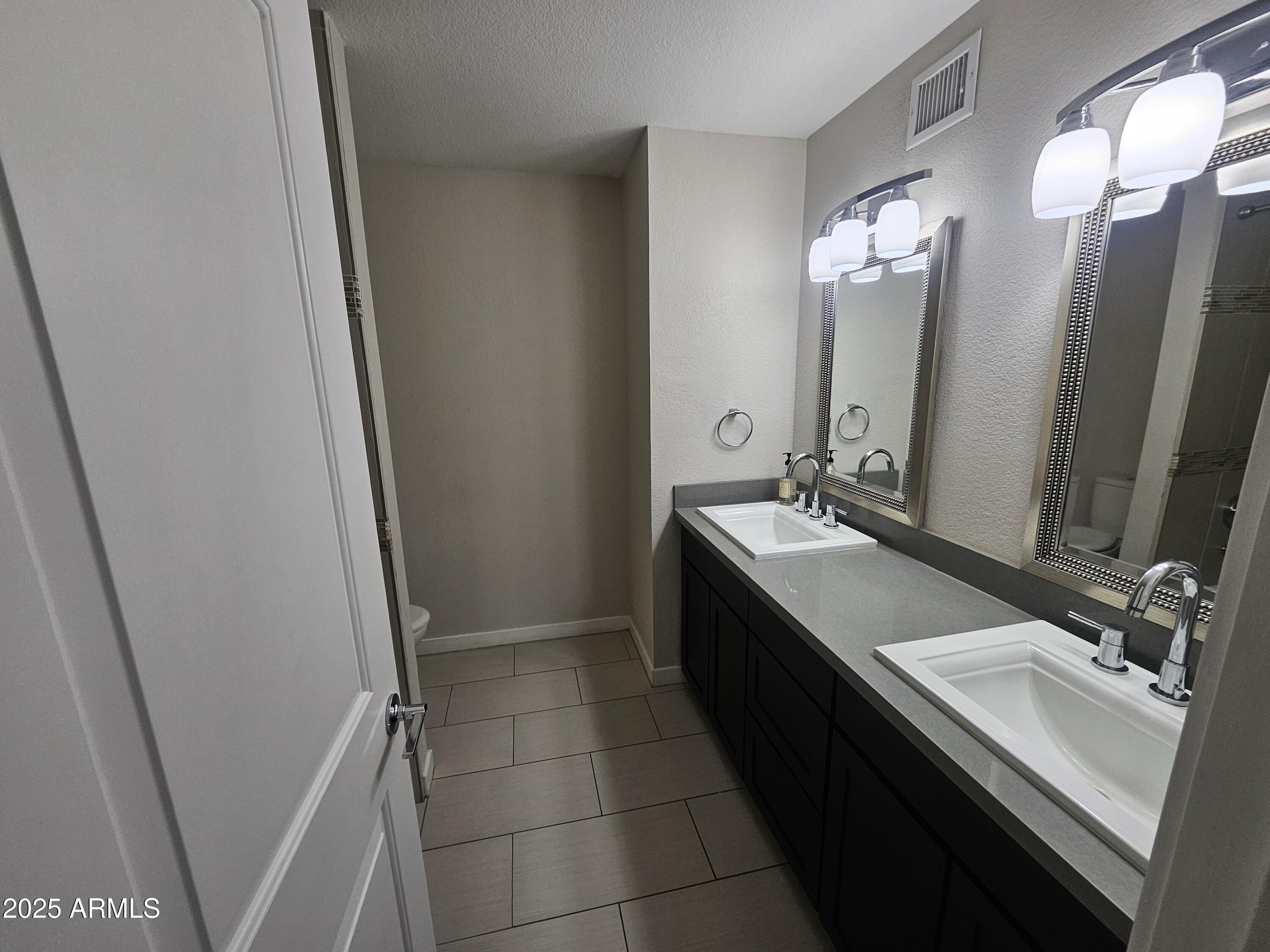 6002 East Marconi Avenue Scottsdale, AZ 85254 - Photo 23 of 29 a bathroom with a double vanity sink a and a mirror