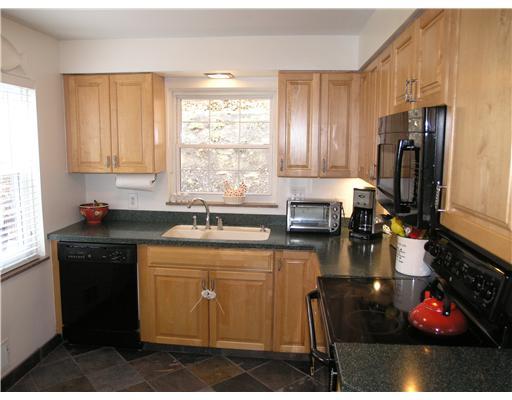 139 Oakhurst Road Pittsburgh, PA 15215 - Photo 7 of 16 Kitchen. The kitchen offers maple cabinetry, solid-surface countertops, new natural slate tile flooring and a patio walkout.