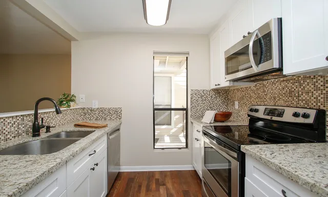 a kitchen with a sink stove and cabinets