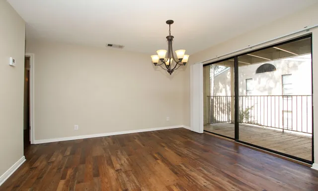 a view of a livingroom with wooden floor and a large window