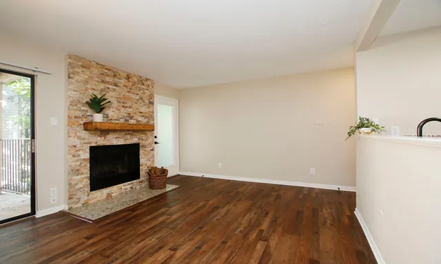a view of a livingroom with wooden floor and a fireplace