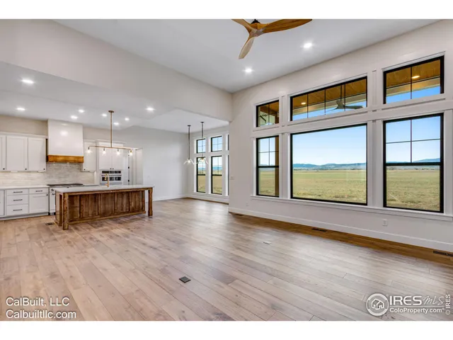 a living room with stainless steel appliances kitchen island wooden floor and dining table