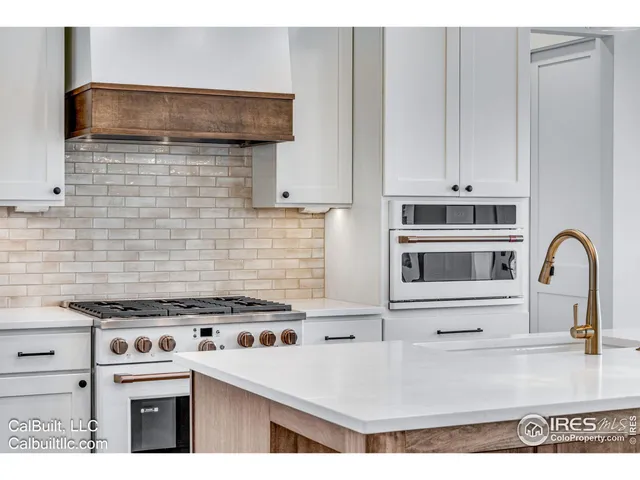 a kitchen with granite countertop a stove a sink and a microwave