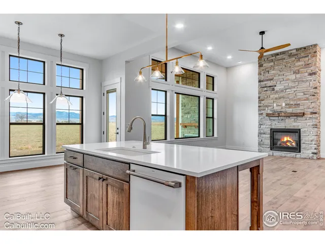 a kitchen with kitchen island a counter top space appliances and a living room view