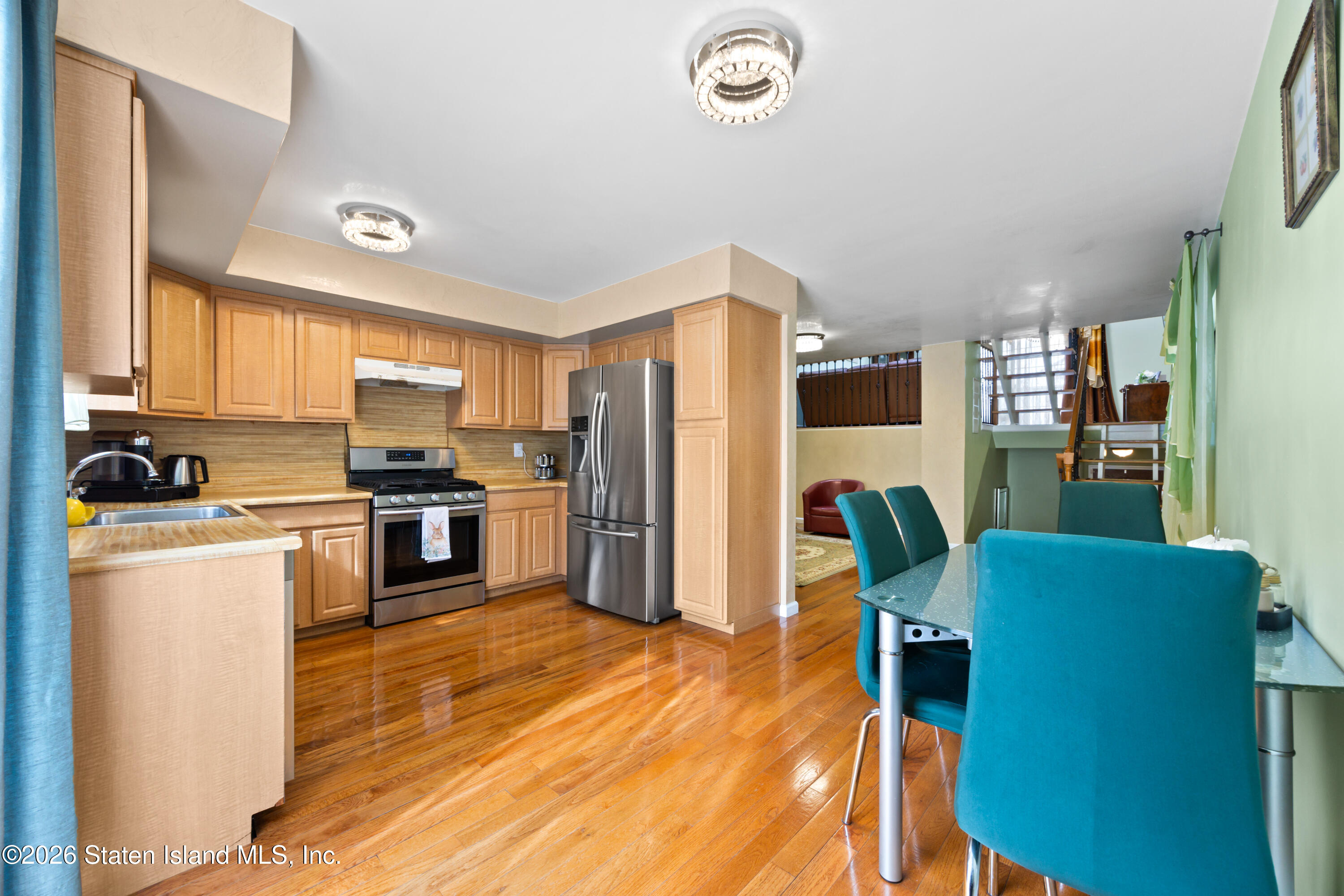 23 Stack Drive Staten Island, NY 10312 - Photo 7 of 29 a kitchen with stainless steel appliances kitchen island granite countertop a refrigerator a stove top oven a sink dishwasher and a dining table with wooden floor