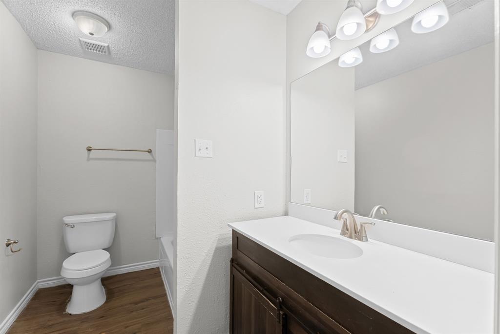 429 Johnson Street, Unit 10 Longview, TX 75602 - Photo 11 of 12 a bathroom with a sink a toilet and a mirror