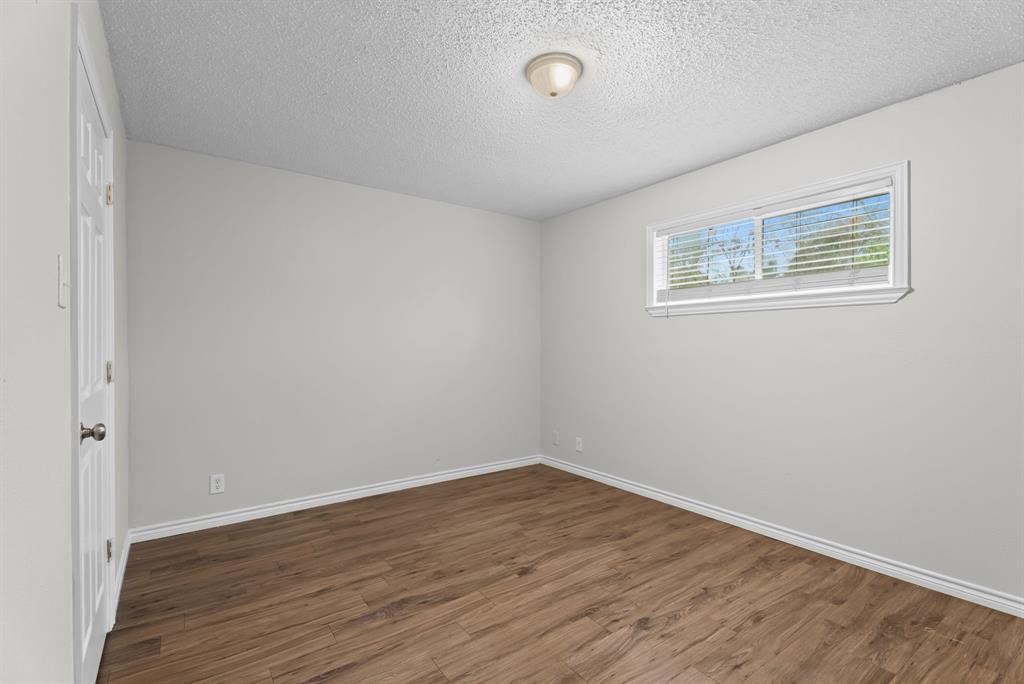 429 Johnson Street, Unit 10 Longview, TX 75602 - Photo 9 of 12 an empty room with wooden floor and windows