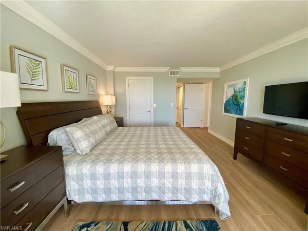 a bedroom with a bed and a flat screen television