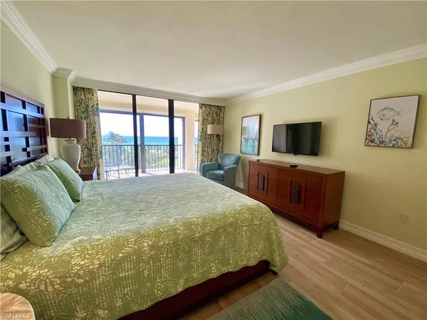 a large bedroom with a bed and flat screen tv