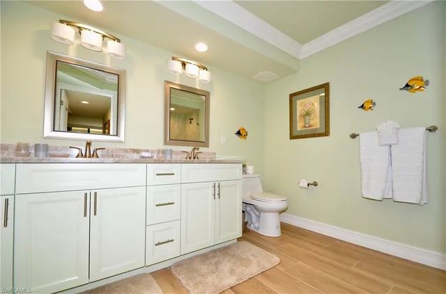 a bathroom with a double vanity sink mirror and toilet