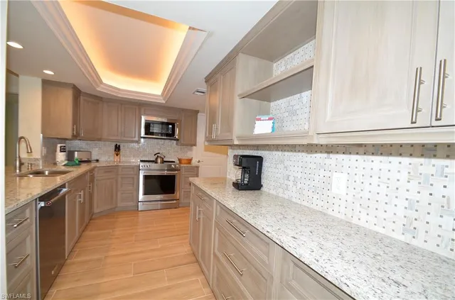 a kitchen with granite countertop a sink stainless steel appliances and cabinets