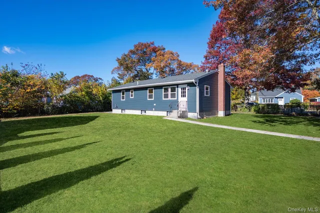 a front view of a house with a garden and trees