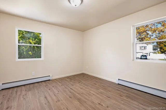 an empty room with wooden floor and window